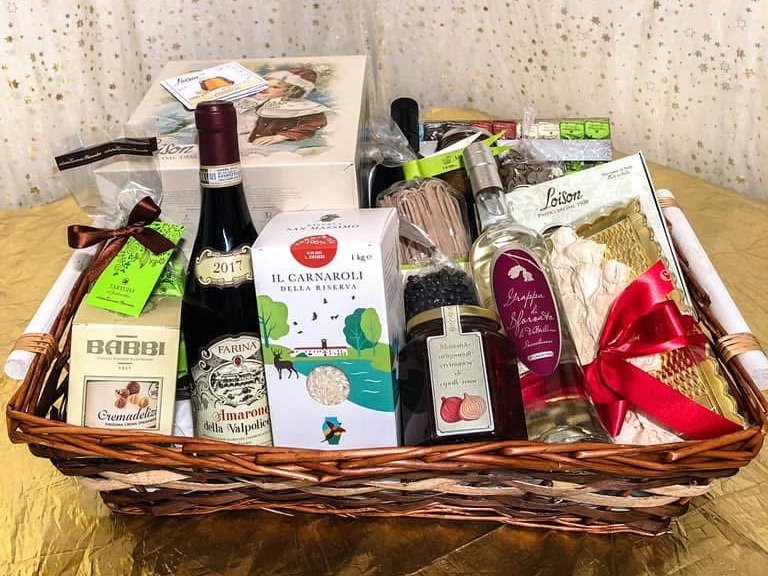 Una cesta in vimini composta da Sapori d'Italia, con vino, riso Carnaroli, grappa, conserve e dolci