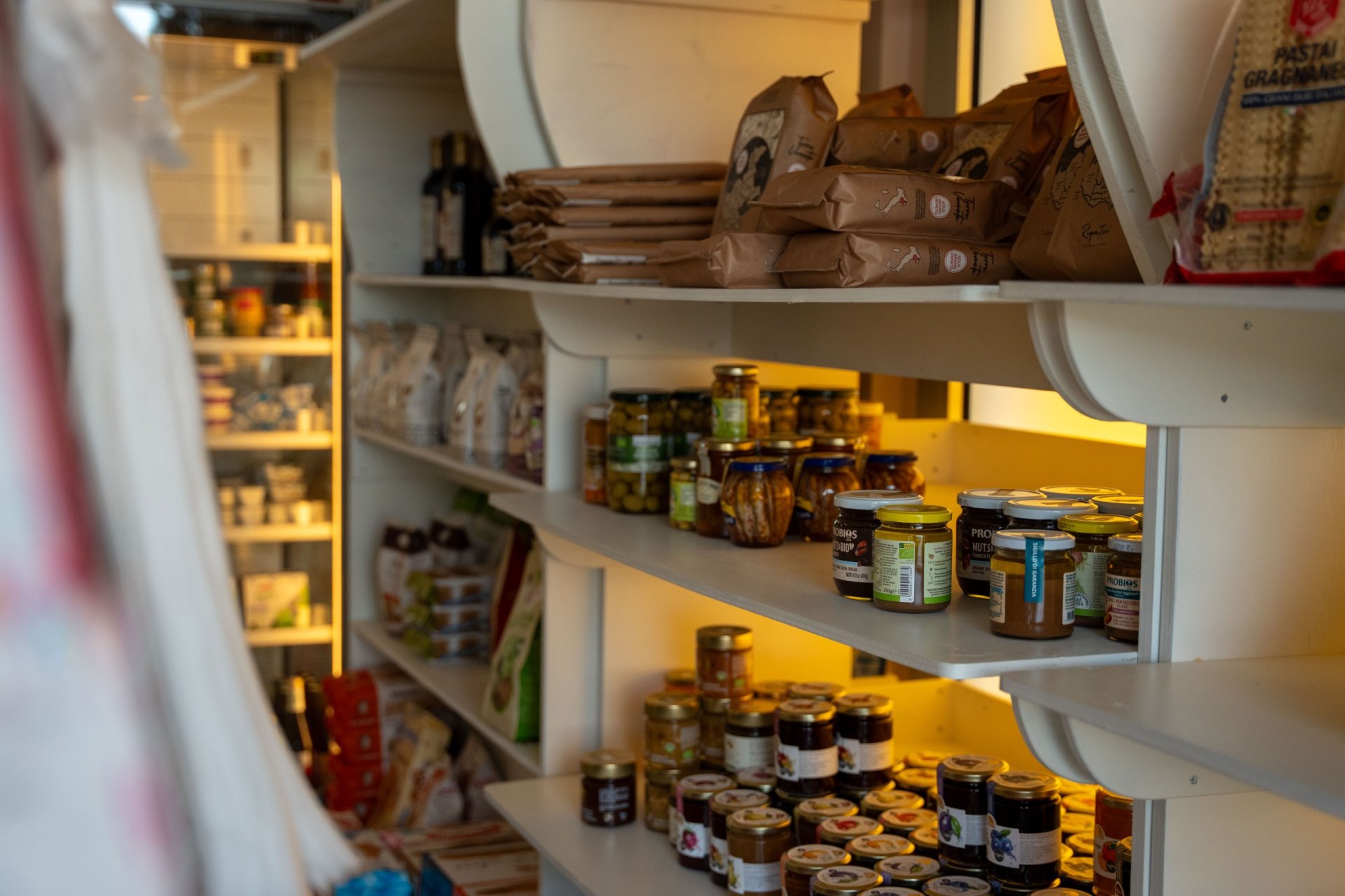 Sughi e conserve in vasetto sugli scaffali della dispensa di Sapori d'Italia